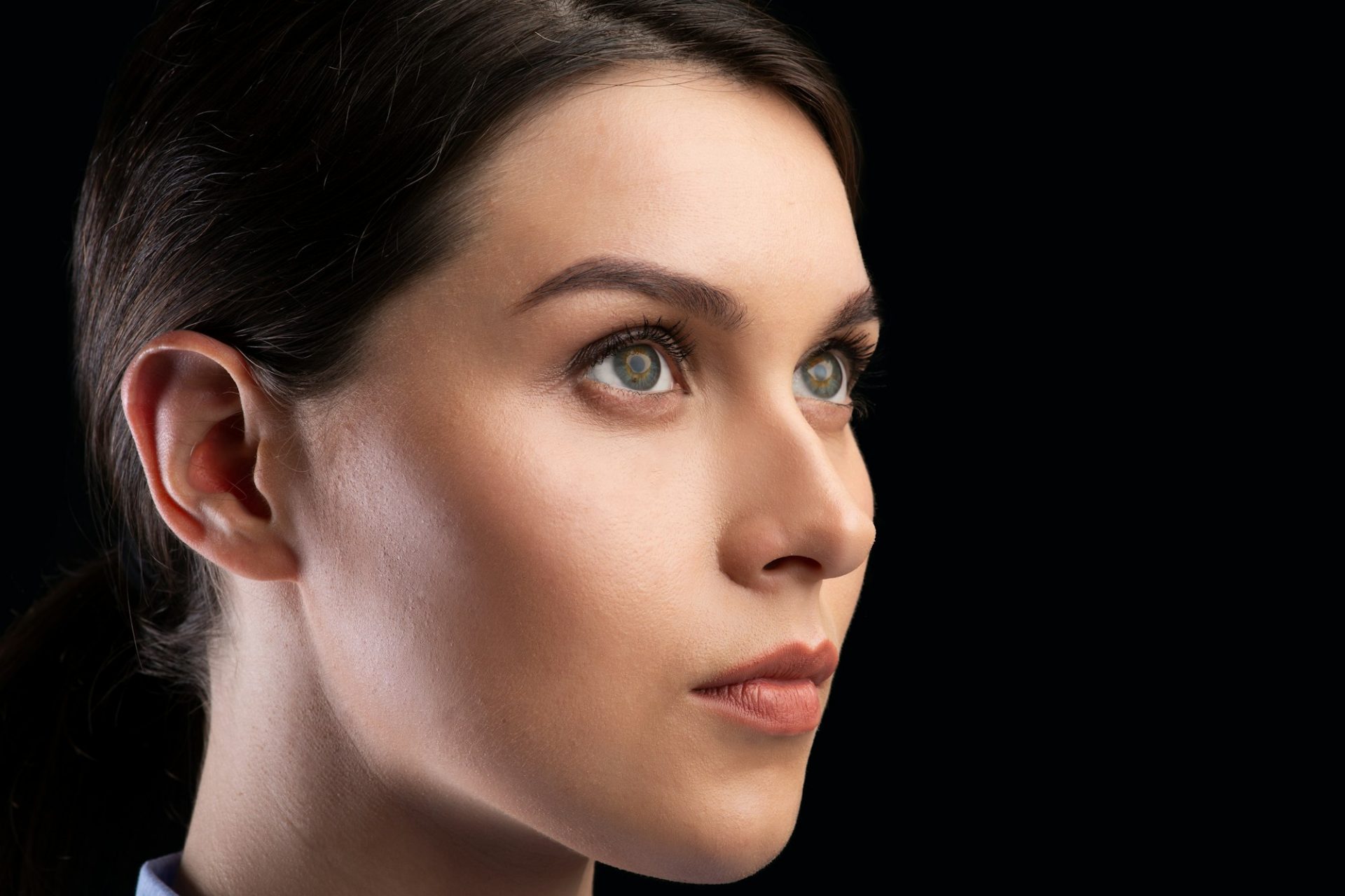 Portrait Of Female Face Staring Aside Over Black Background