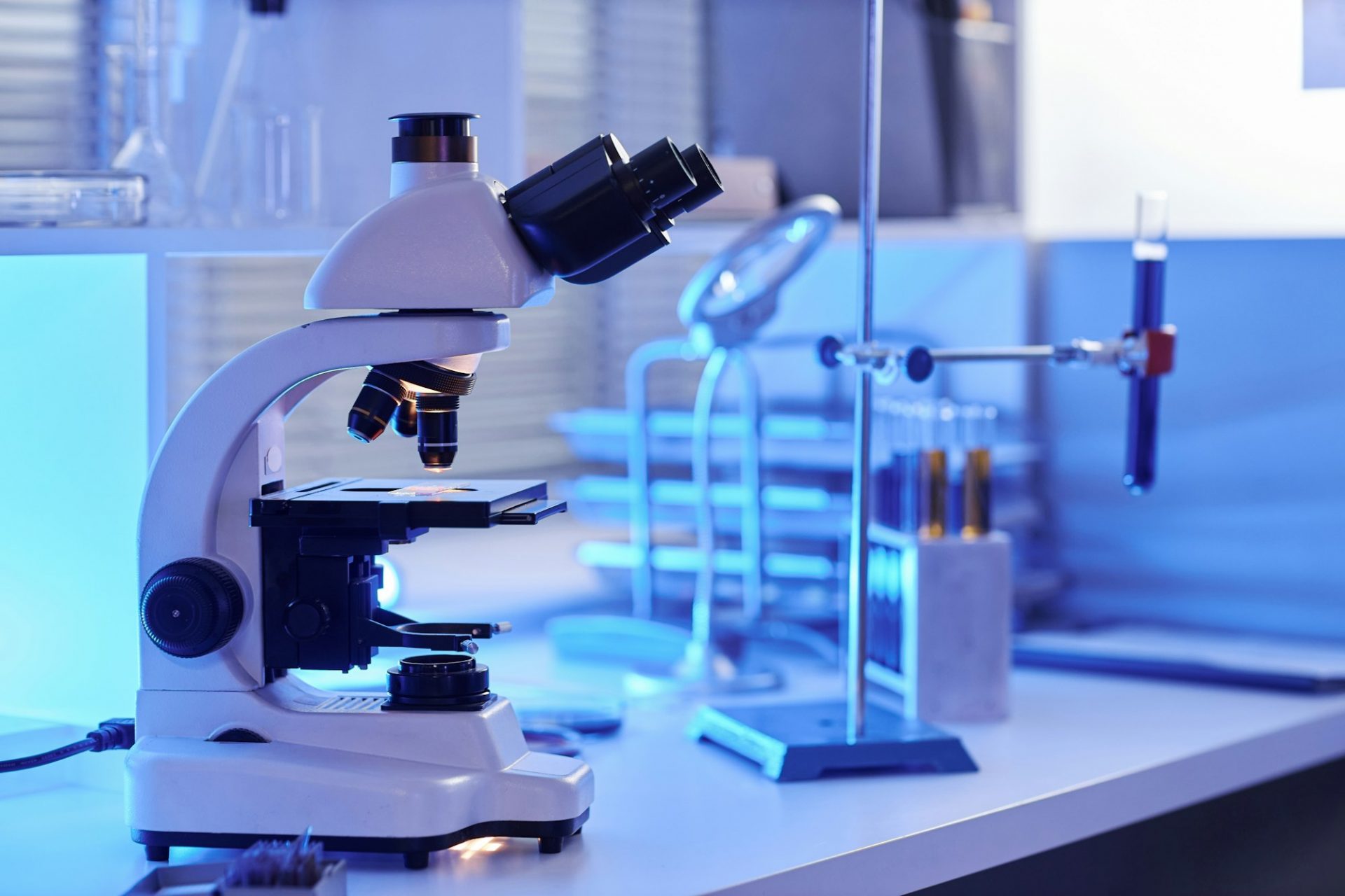 Side view electronic microscope on laboratory workstation in neon light