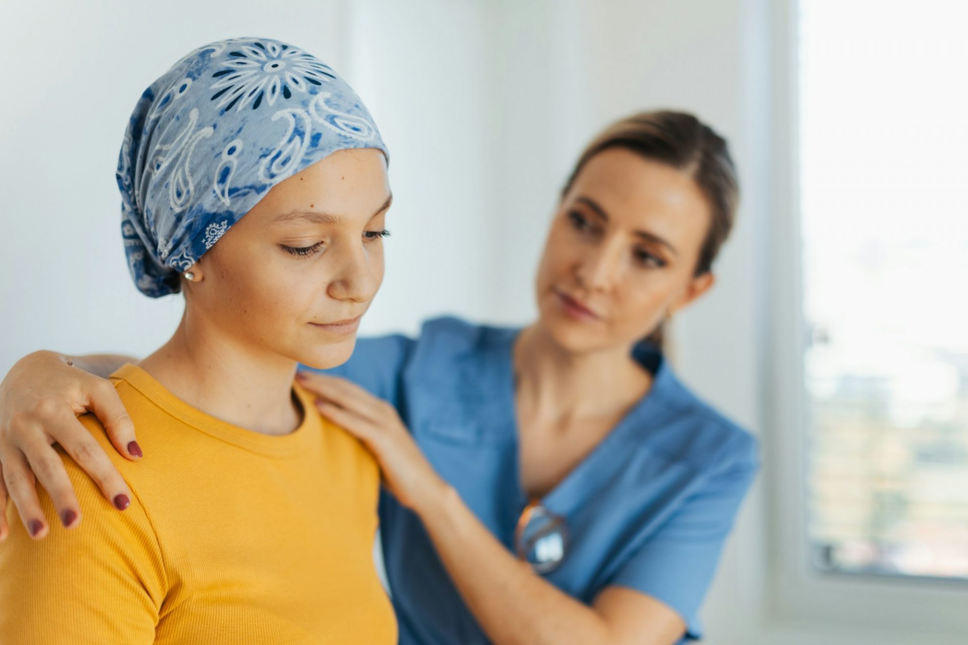 Teenage oncology patient talking with doctor. Oncologist treating teen girl with cancer and provide